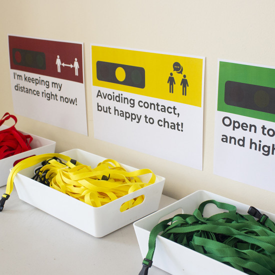 Green, yellow and red traffic light lanyards in separate baskets with posters above them