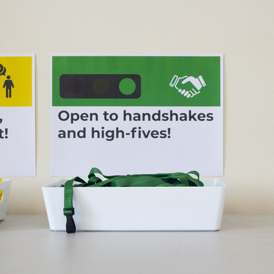 Green, yellow and red traffic light lanyards in separate baskets with posters above them