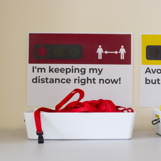 Green, yellow and red traffic light lanyards in separate baskets with posters above them