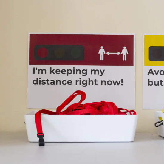 Green, yellow and red traffic light lanyards in separate baskets with posters above them
